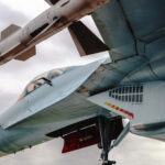 Fighter with missiles under the wing against the sky