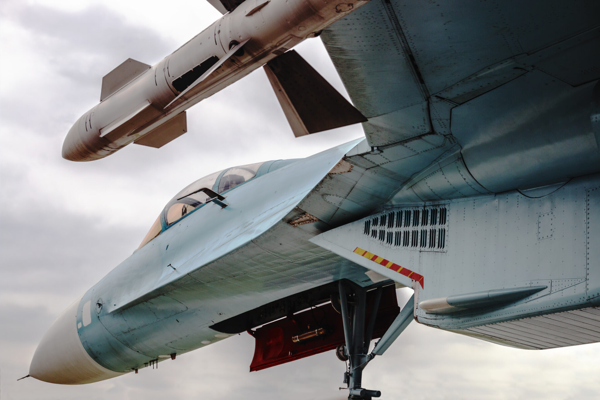 Fighter with missiles under the wing against the sky