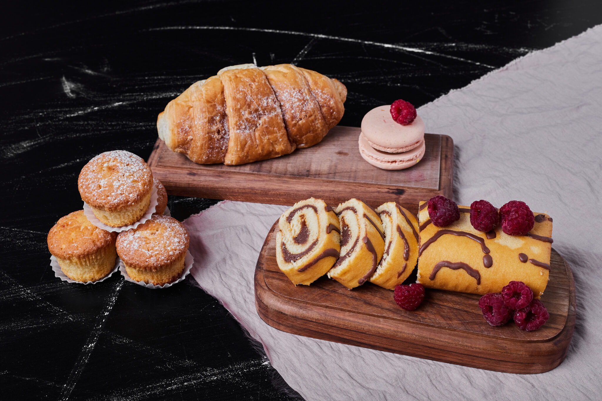 Rollcake with berries on a platter with muffins. High quality photo